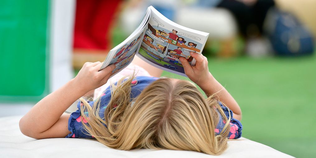 niña de espalda leyendo un libro